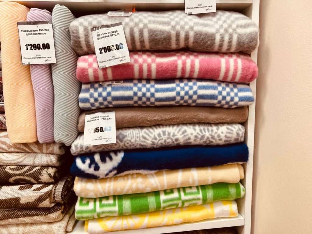 Байковые одеяла в магазине на полке